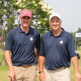 Two golfers smiling at camera
